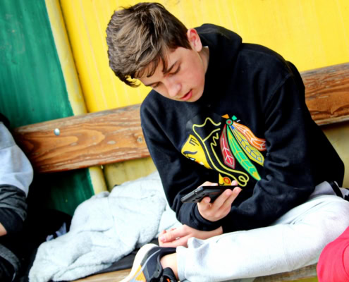 Kinder und Handy Junge sitzt auf Boden