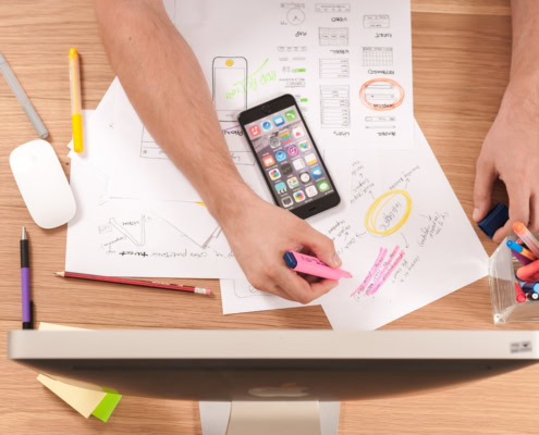 Schüler arbeitet am Bildschirm und recherchiert am Handy