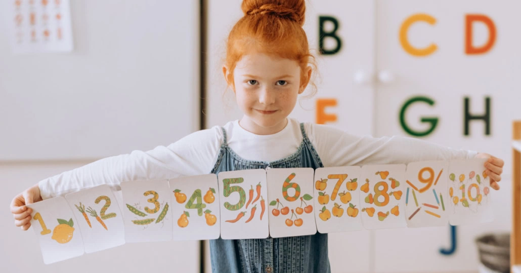 Mädchen hält gepasteltes Plakat zur Zahlenreihe hoch